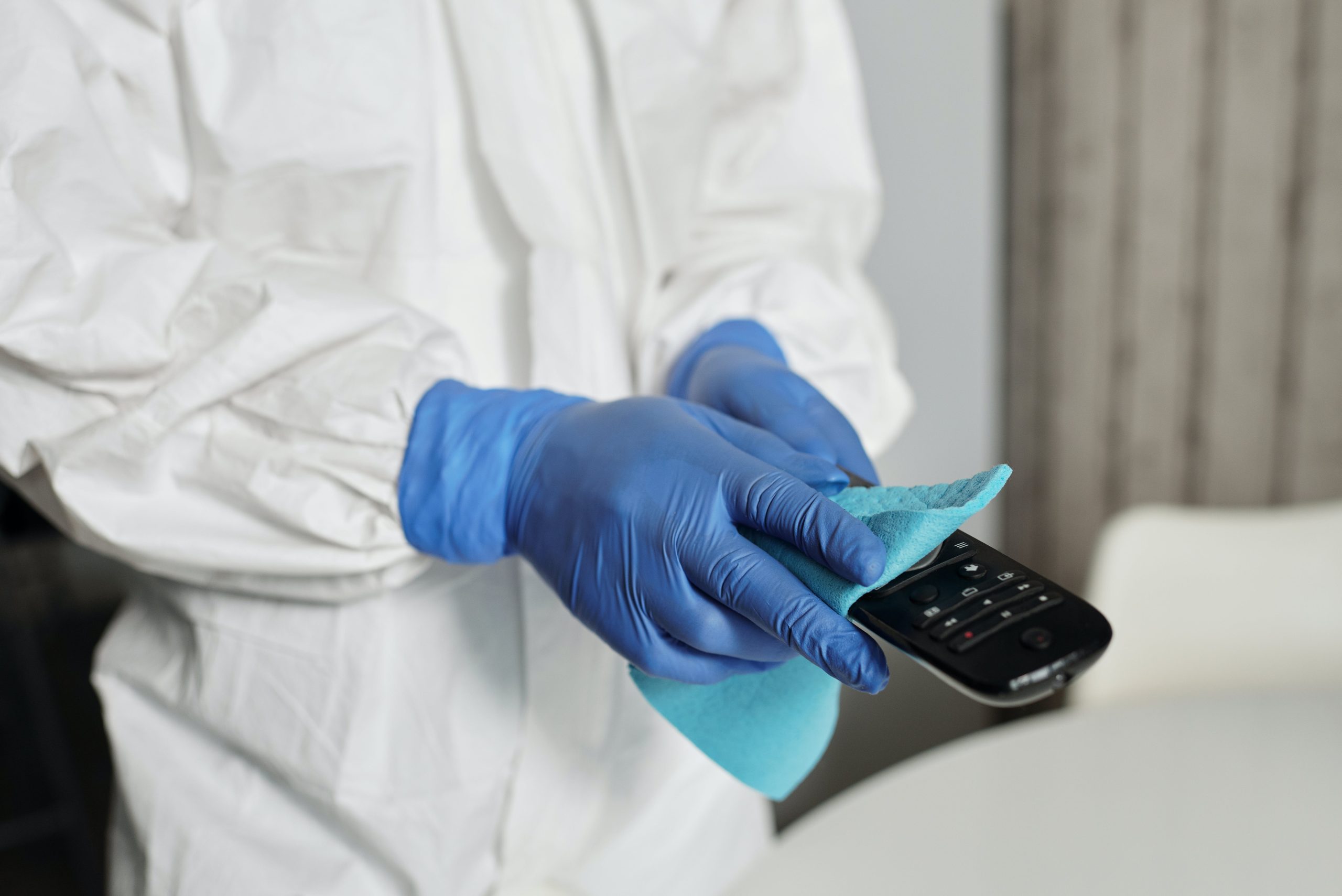 Cleaner wiping down a high touch point during commercial cleaning