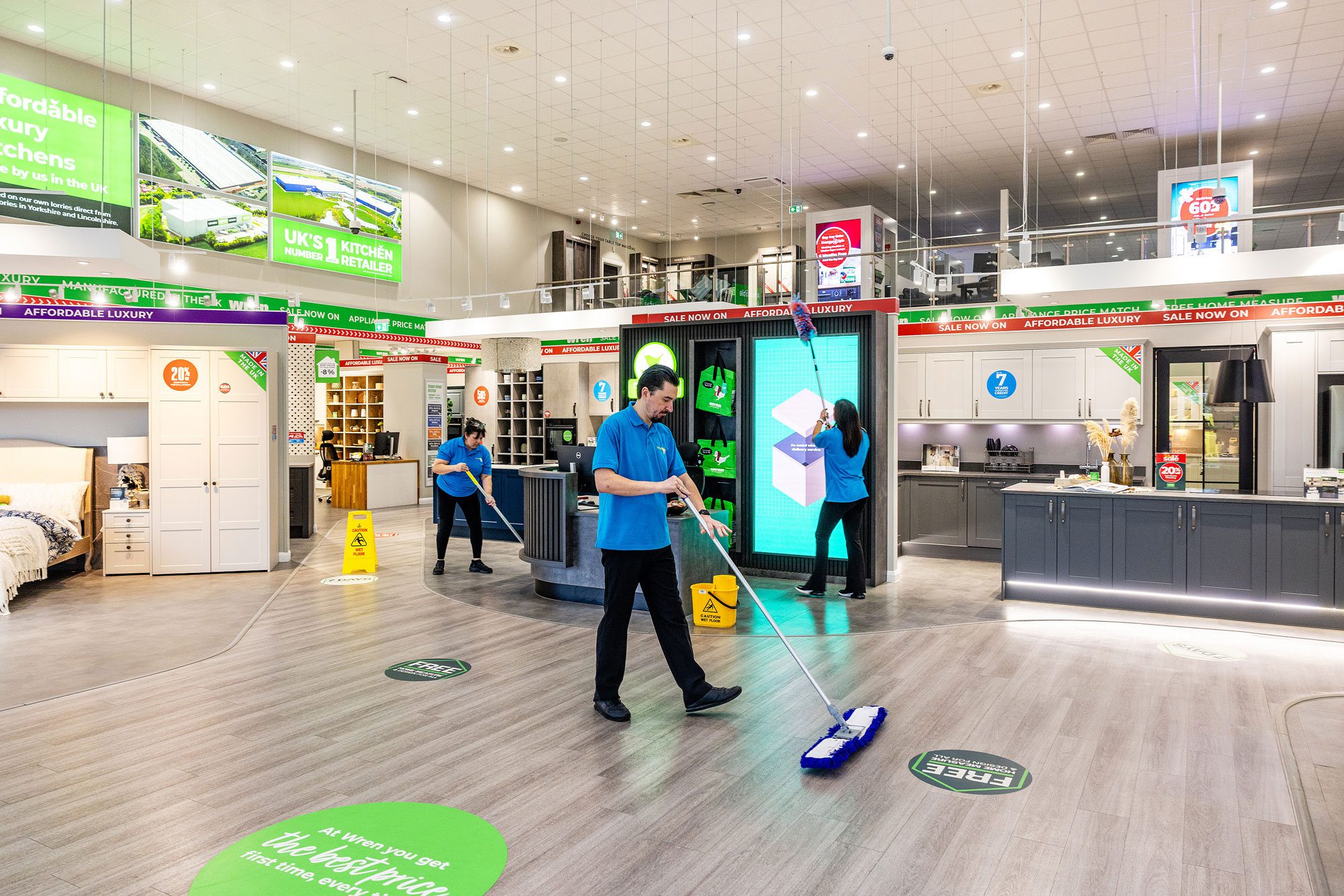 male and female cleaners cleaning kitchen showroom
