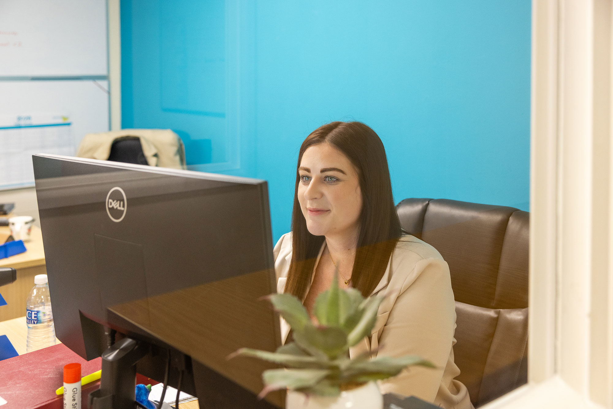 women working in office environment with large dell screen